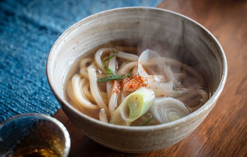 Soupe Udon végan avec tempura servie dans un bol.