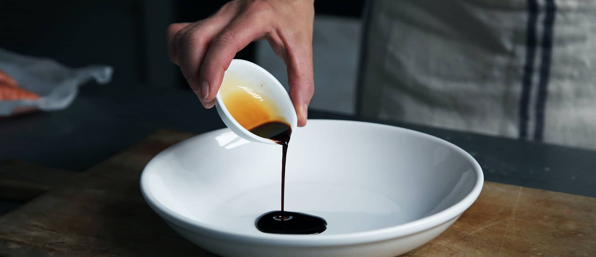 Japanese sauce being poured in an empty white bowl